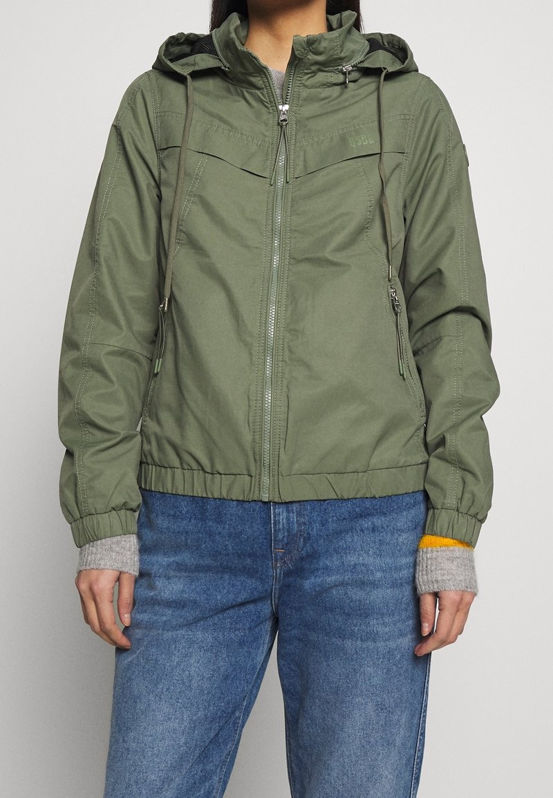 Olivengrøn hættejakke i letvægtsmateriale med lynlås foran, elastiske manchetter og kant; har to sidelommer og et enkelt design.