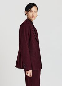 Giacca da abito bordeaux con righe sottili, monopetto, con rever a punte, due tasche frontali e dettagli a bottoni sui polsini.