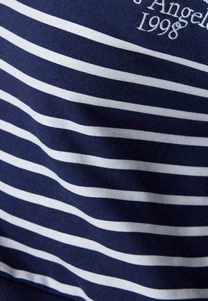 Marineblauwe katoenen stof met witte horizontale strepen, met geborduurde tekst "Los Angeles 1998" in het wit. Gladde textuur, casual ontwerp.