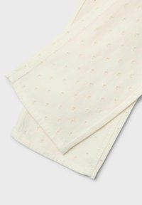 Tissu en coton blanc avec un motif texturé de petits points en relief. Les bords ourlés et la finition lisse mettent en valeur le design.
