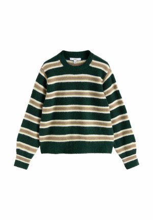 Young woman with long blonde hair wearing a dark green striped sweater looks away with a neutral expression outdoors in daylight.