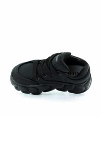 Czarne sneakersy z teksturowaną, wyściełaną cholewką, z okrągłymi otworami na sznurówki, masywną podeszwą i gładką powierzchnią. Minimalne logo na języku.