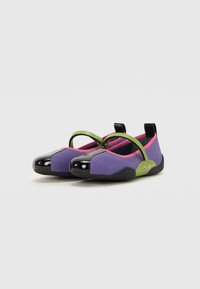 Sapatos planos de malha roxos com a ponta preta e brilhante, realces em verde e rosa, e uma tira para um ajuste seguro. Sola texturizada para maior aderência.