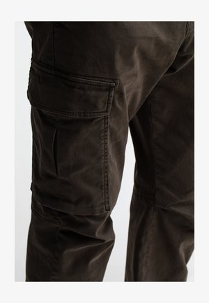 Donkerbruine cargobroek met zijzakken, gemaakt van een gestructureerde stof. Kenmerkt zichtbare stiksels en een relaxte pasvorm.