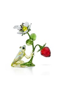 Frog di cristallo giallo e trasparente, posato su un gambo verde con un fiore bianco e una fragola rossa sfaccettata. Accento di ape sopra il fiore.