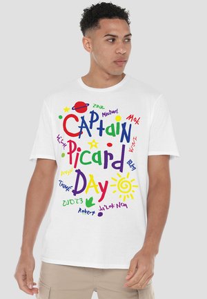 White short-sleeve t-shirt featuring colorful text design with "CAPTAIN PICARD DAY" and various names in playful fonts and elements like stars and planets.