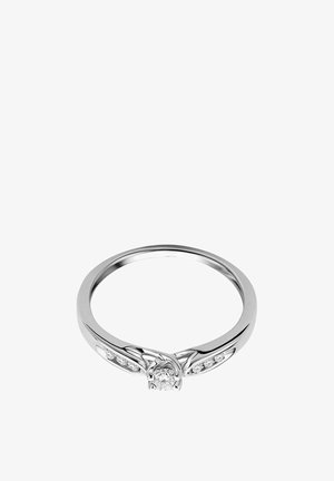 Hõbe sõrmus, mille keskel on teemant ja väiksemad külgdotsendid. Omab siledat bändi, millel on keerukad, kõverad detailid keskel.