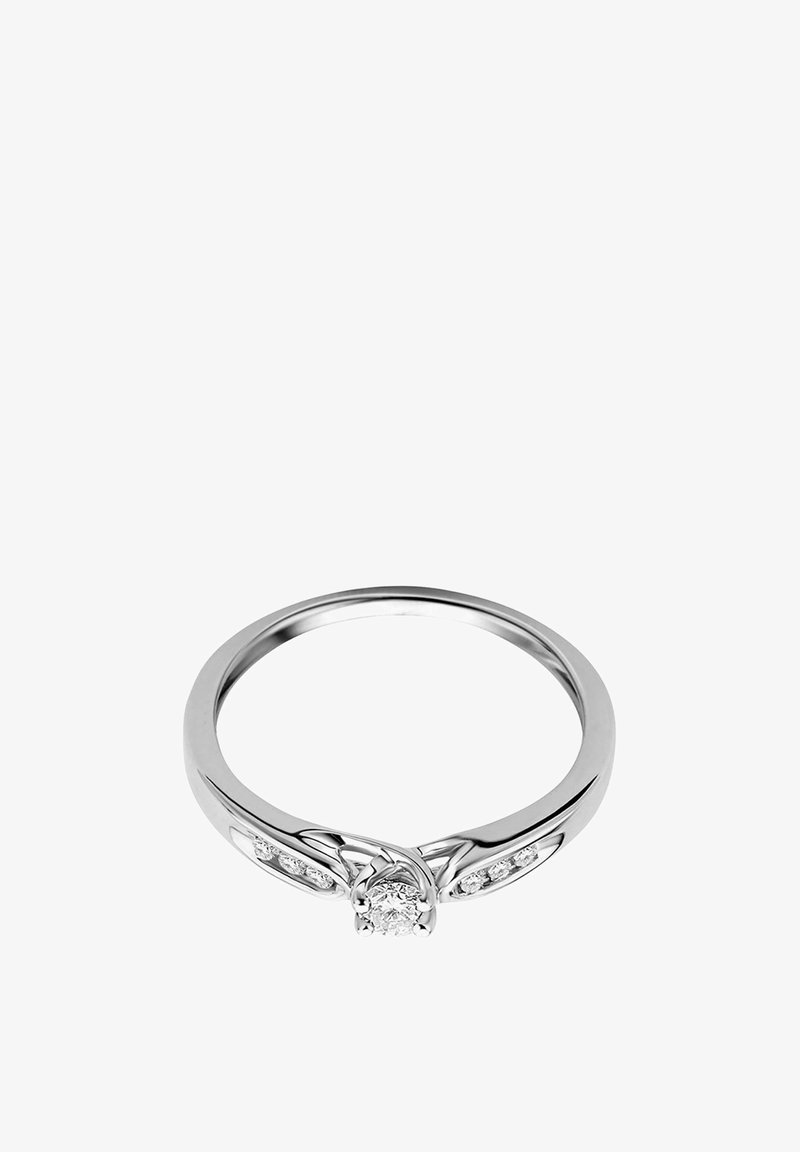 Strieborný prsteň so stredným diamantom a menšími bočnými diamantmi. Má hladký pás s jemnými, zakrivenými detailmi okolo stredu.
