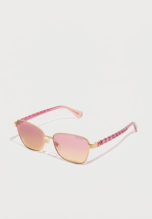 Gold-framed sunglasses with pink gradient lenses and textured pink arms, angled on white surface casting soft shadows.