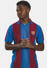 Voetbalshirt van Barcelona met verticale strepen in kastanjebruin en blauw, met een kraag en het clubembleem aan de linkerkant. Korte mouwen.