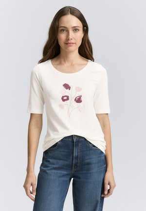 Lichtcreme t-shirt met korte mouwen, ronde halslijn, featuring een bloemenprint in tinten paars, gecombineerd met blauwe denim jeans.