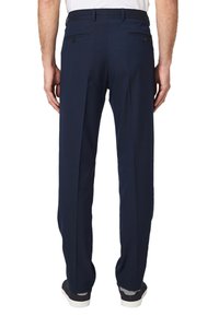 Marine blauwe dresspants met een getailleerde pasvorm, voorzien van twee achterzakken met knoopsluitingen en een gladde textuur. Gekocht met casual sneakers.