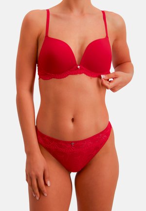 Red bra and matching lace panties. Smooth fabric with a scalloped lace trim and decorative detail at the center. Adjustable straps.
