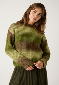 Textured groene trui met ribgebreid patroon, voorzien van gradiënt tinten van groen en paars. Lange mouwen en ronde hals.