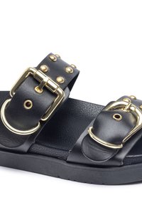 Zwarte leren sandalen met gouden gespsluitingen en studs, voorzien van een structuurvoetje en een stevige zwarte rubberen zool.