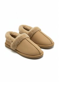 Par de zapatillas sin cordones de color marrón claro con forro y ribete de piel suave, diseñadas para proporcionar comodidad y calidez en interiores, sobre un fondo blanco liso.