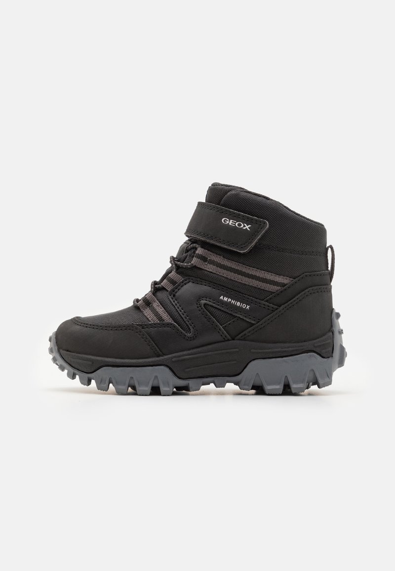 Botte de randonnée haute noire avec semelle grise robuste, bride velcro, lacets et marquage de la technologie Amphibiox imperméable et respirante.