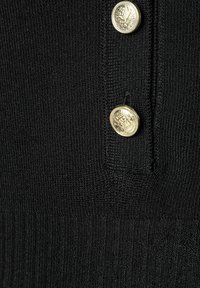 Schwarzer Strickstoff mit gerippter Textur, versehen mit drei goldenen Knöpfen mit eingeprägten Designs an der Vorderöffnung.