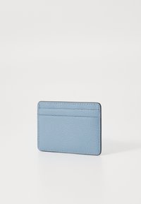 Jasnoniebieski skórzany portfel na karty o fakturowanej powierzchni, z wieloma przegródkami na karty i kontrastującymi czarnymi krawędziami. Kompaktowy prostokątny kształt.