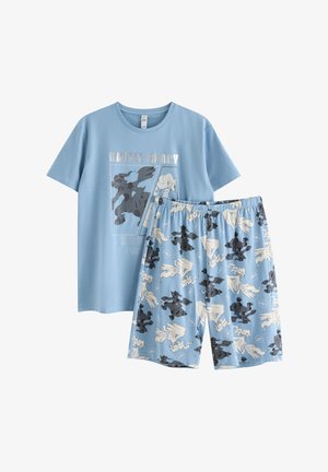 Camisa de manga corta azul claro con texto "Listo para la batalla" y dos gráficos de criaturas, combinada con pantalones cortos a juego que presentan un patrón repetido de criaturas en blanco y negro.