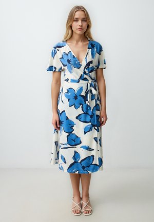 Das Blumenwickelkleid zeigt blaue und schwarze Blumenmuster auf einem cremefarbenen Hintergrund, hat einen V-Ausschnitt, kurze Ärmel und eine seitliche Bindegurt-Detail.