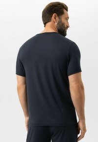 Granatowy t-shirt z krótkim rękawem, z okrągłym dekoltem, wykonany z miękkiego materiału o gładkiej strukturze. Charakteryzuje się prostym wzornictwem i luźnym krojem.