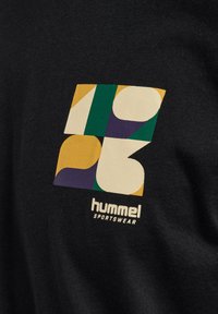 Czarna koszulka z wielokolorową grafiką geometryczną zawierającą elementy w kolorze żółtym, zielonym, fioletowym i beżowym. Poniżej znajduje się logo "Hummel Sportswear".