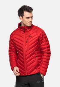 Rote isolierte Jacke mit Reißverschluss vorne, hohem Kragen, Chevron-Muster und Reißverschlusstaschen. Das Material wirkt glatt und leicht.