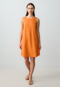Orange leinen ärmelloses Kleid mit rundem Ausschnitt, A-Linie und glatter Textur. Der Saum ist leicht ausgestellt, um die Bewegungsfreiheit zu erleichtern.