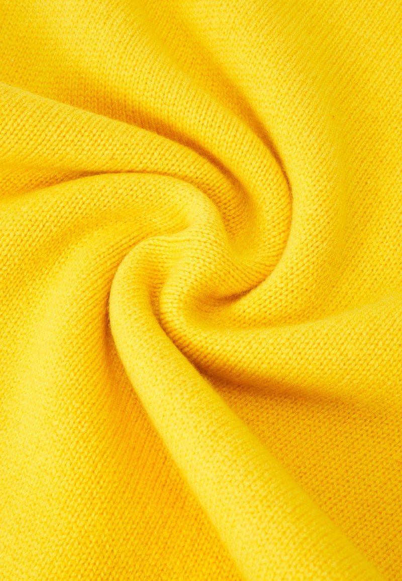 Jasnożółty materiał z miękkim, teksturowanym splotem. Tkanina wydaje się lekka, ma gładkie wykończenie i lekki stretch.