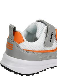 Sneaker grigio e bianco con accenti arancioni; parte superiore in rete, suola in gomma, collo imbottito e cinturino in Velcro; presenta superfici testurizzate e lisce.