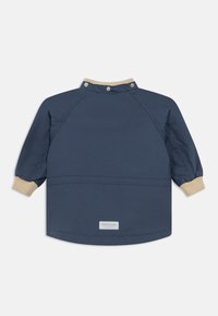 Σκούρο μπλε μπουφάν με μπεζ ριμπ γιακά και μανσέτες, κούμπωμα με κουμπιά στον λαιμό και μικρή ετικέτα στο κάτω μέρος της πλάτης.