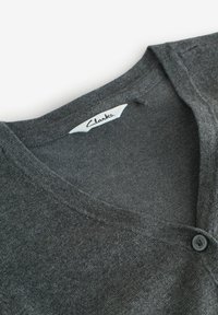 Cardigan in cotone grigio con scollo a V e chiusura con bottoni. Presenta una texture morbida e cuciture sottili. L'etichetta riporta "Clarks."