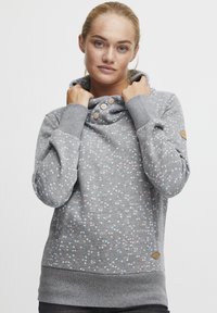 Sudadera gris claro con cuello de cowl, que presenta un patrón de puntos de colores y botones cerca del escote. Tejido suave, puños y dobladillo acanalados.