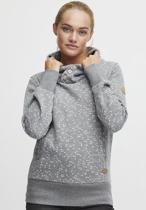 Sweatshirt gris clair avec un col cheminée, arborant un motif de pois colorés et des boutons près de l'encolure. Tissu doux, poignets et ourlet côtelés.
