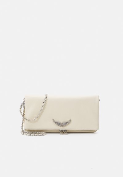 Beige leather clutch with metallic chain shoulder strap, flap closure, and decorative silver wing accent. Smooth texture with minimalist design.