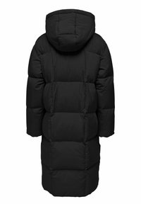 Svart pufferjakke med hette. Har en kviltet design, oversized silhuett og store polstrede seksjoner. Tykt stoff og lange ermer.