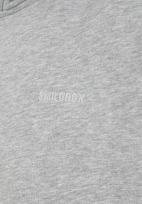 Gray sweatshirt with a heathered texture, featuring an embossed logo "SMILODOX" in white, positioned centrally on the front.
