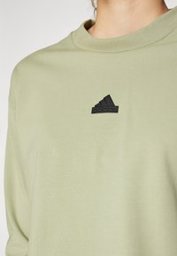 adidas Sportswear FUTURE ICONS THREE STRIPES LONG SLEEVE - Hosszú ujjú felső - tent green