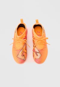 Oranžid spordijalatsid tekstuurse kootud ülaosaga, millel on roosad rõhutused ja iseloomulik logodisain. Paelad on erkoranžid.