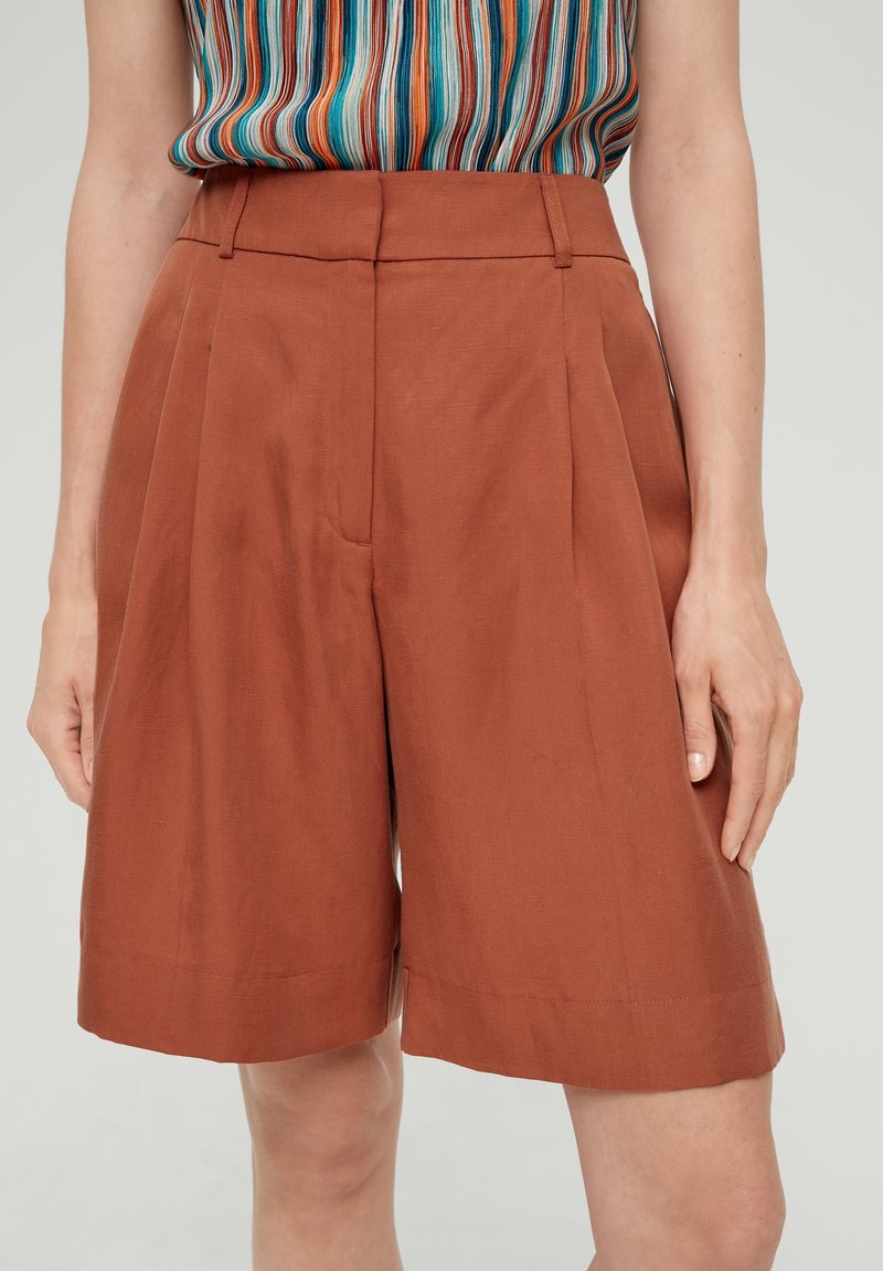 Bruine geplooide shorts gemaakt van een lichtgewicht stof. Heeft een hoge taille en een rechte, relaxte pasvorm met omgeslagen zomen aan de onderkant.