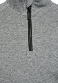 Grå strikket hættetrøje med en sort lynlås foran, delvist lynet op, der viser kraven og den øverste del af brystet.