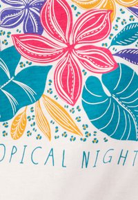 T-shirt met een bedrukte afbeelding van levendige bloemen in roze, paars en geel, en groene tropische bladeren op een witte achtergrond. De tekst luidt "TROPICAL NIGHT."