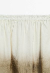 Let skørt i let materiale med elastisk talje, med et ombre-design der overgår fra creme til lys brun. Glat tekstur.