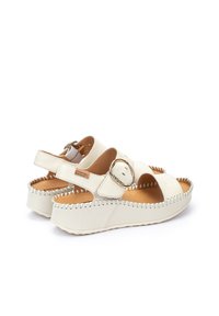 Sandales à plateforme en cuir blanc avec des sangles croisées et une boucle en métal. Détails cousus le long de la semelle et design à bout ouvert. Doublure intérieure douce.