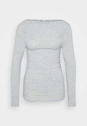 T-shirt à manches longues gris clair, fabriqué en tissu doux et texturé. Il présente une encolure bateau et des détails froncés sur les côtés pour une silhouette ajustée.