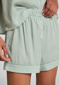 Lichtgroene en witte gestreepte shorts met een elastische tailleband, knoopsluiting en opgerolde mouwen. Zacht materiaal met een ontspannen pasvorm.