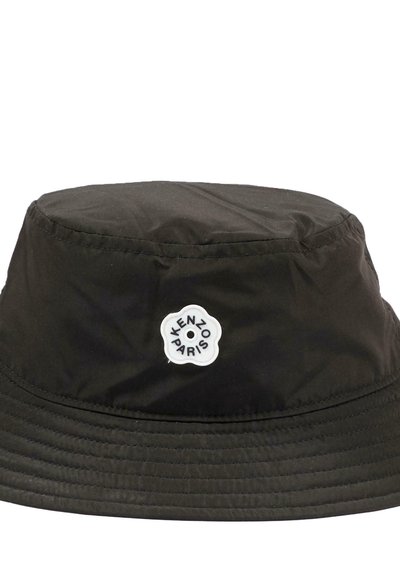 Chapeau bob noir en tissu léger, avec un patch rond blanc portant le texte "KENZO PARIS". Texture lisse, bord cousu.