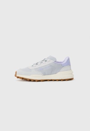 Light grey athletic shoes with mesh and synthetic upper, white accents, purple heel detailing, and a textured beige rubber sole.