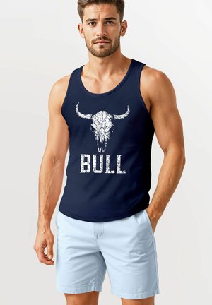 Navy Tanktop mit einem weißen Bullenkopf-Graphic und dem Text "BULL" darunter; kombiniert mit hellblauen Shorts aus glattem Stoff und lockerem Schnitt.